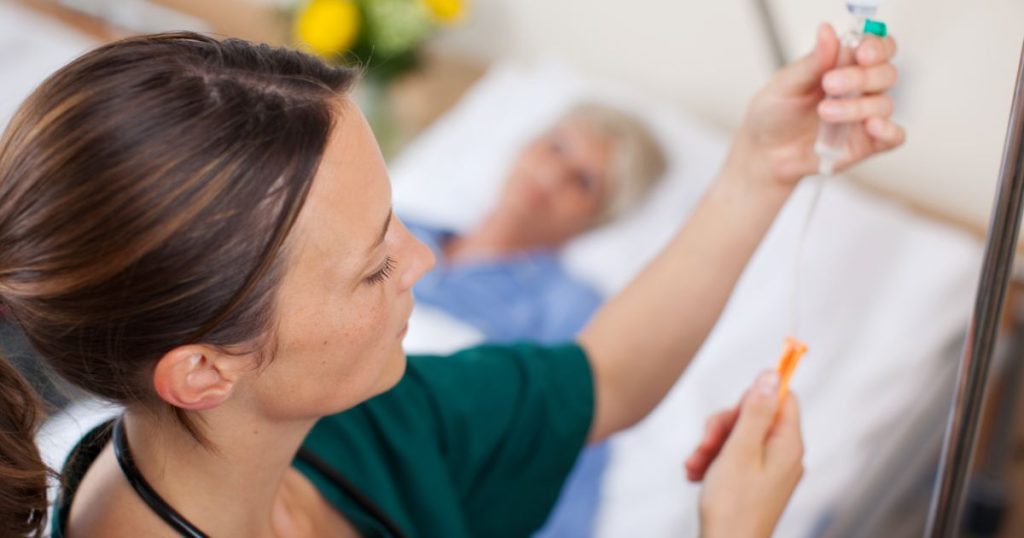 nurse adjusting an IV